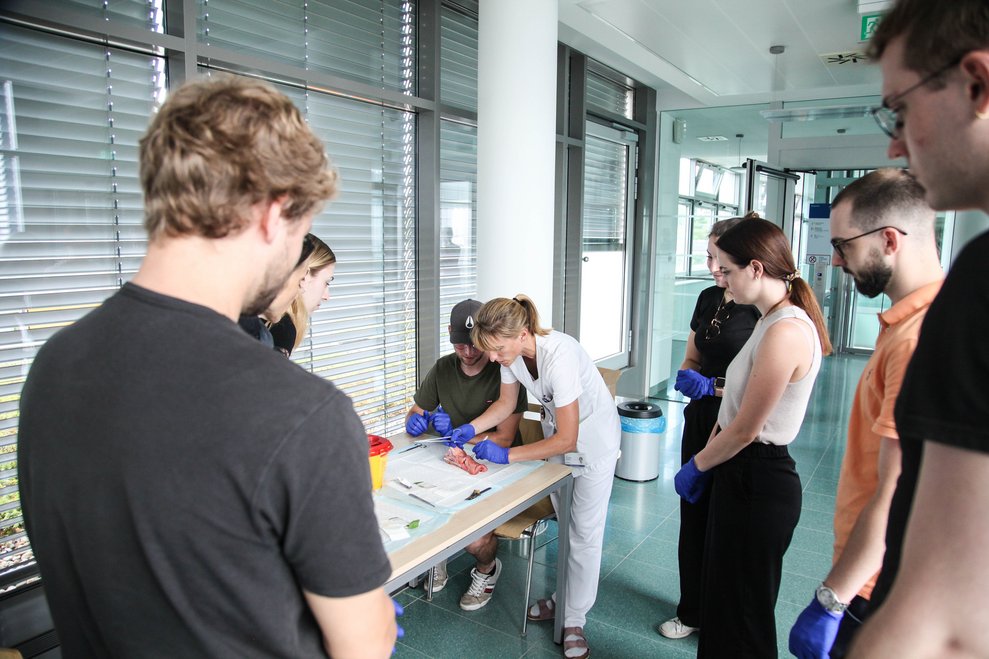 Studierende schauen einem Kollegen über die Schultern