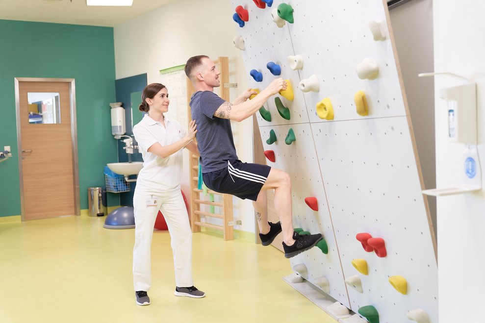 Patient klettert auf einer Boulderwand hinauf